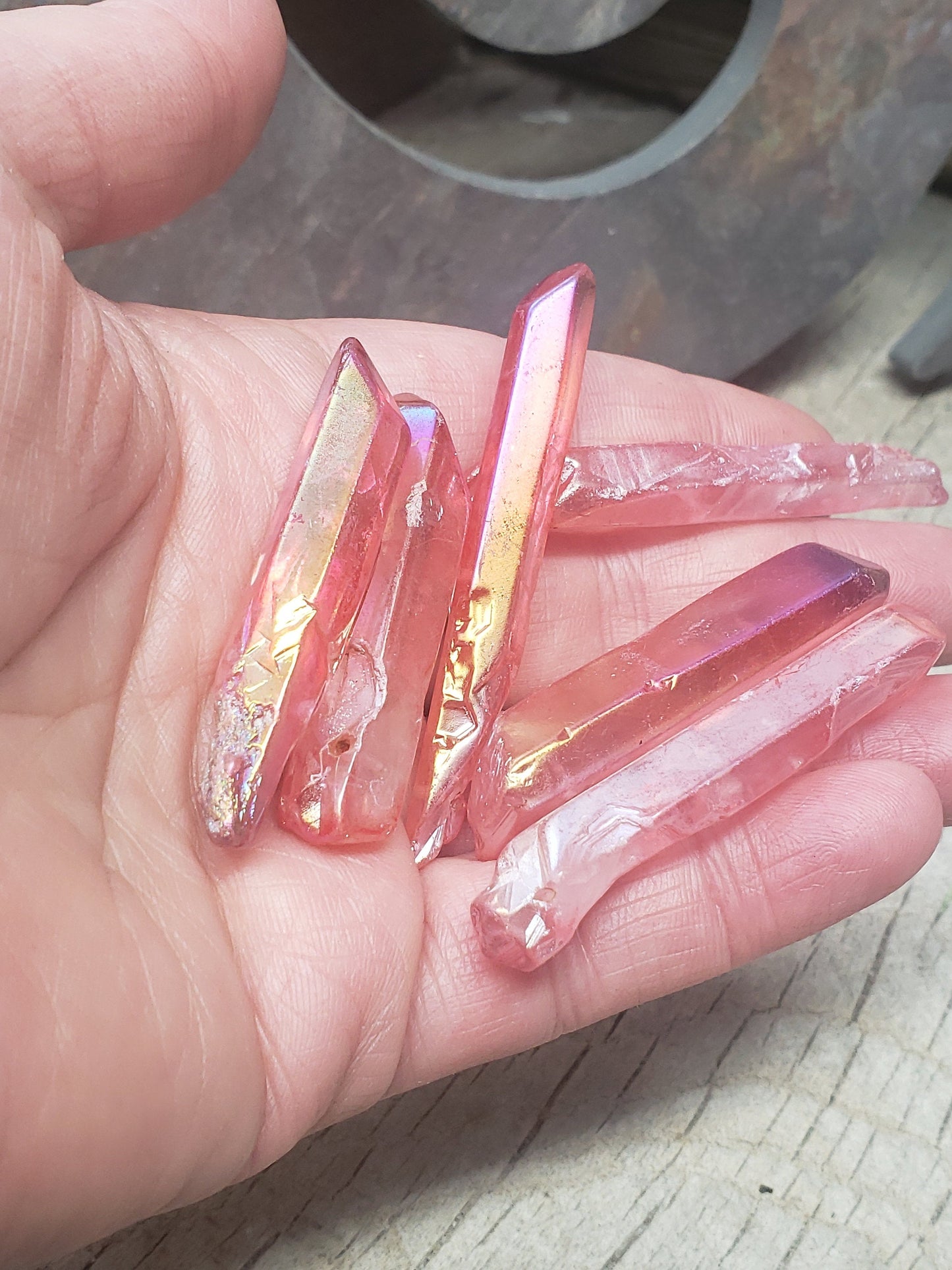 Sparkling pink aura quartz crystal point beads held in a hand  - radiating gentle elegance and positive energy.