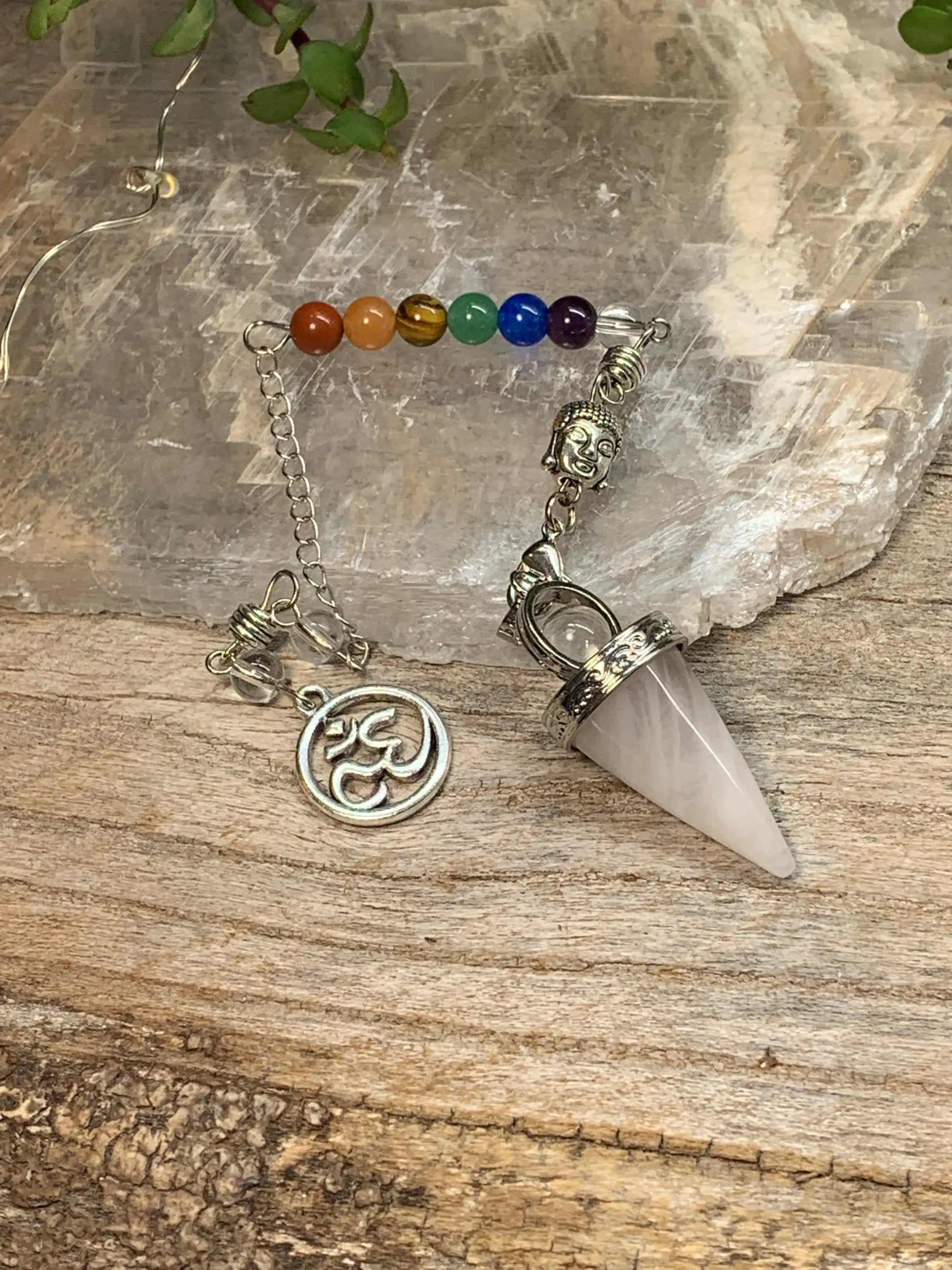 1 inch, cone shaped, rose quartz pendulum attatched to an 8 inch silve chain including chakra beads, diva bead and ohm symbol