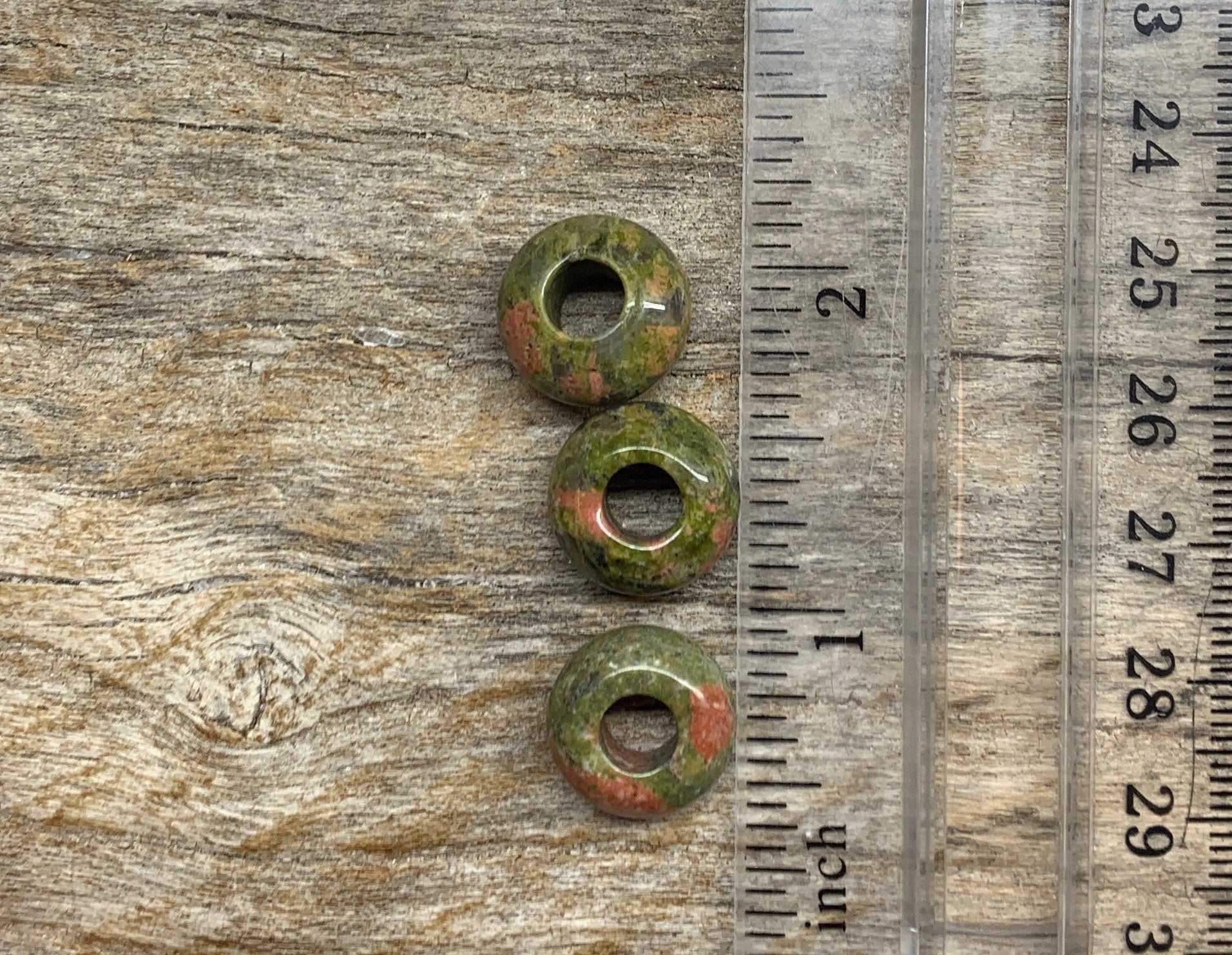 Unakite Jasper beads featuring earthy green and peach tones, next to a ruler