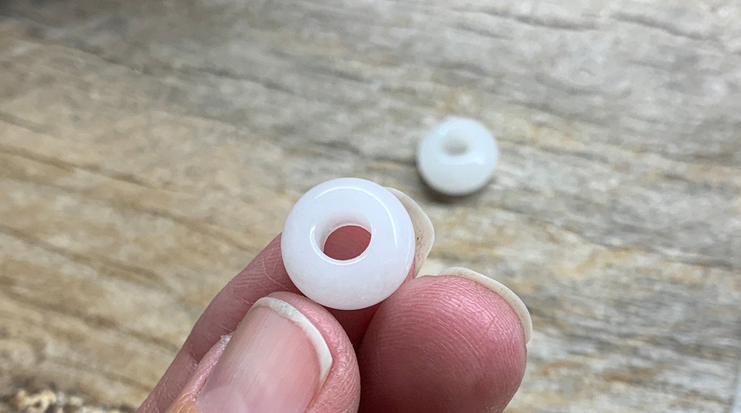 Close-up of 14mm snow quartz crystal beads, showcasing their translucent white color and smooth surface texture