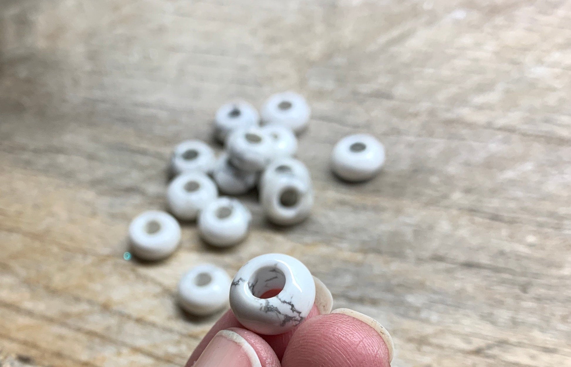 "Close-up of 5/8 inch white Howlite beads with intricate natural veining and smooth texture.