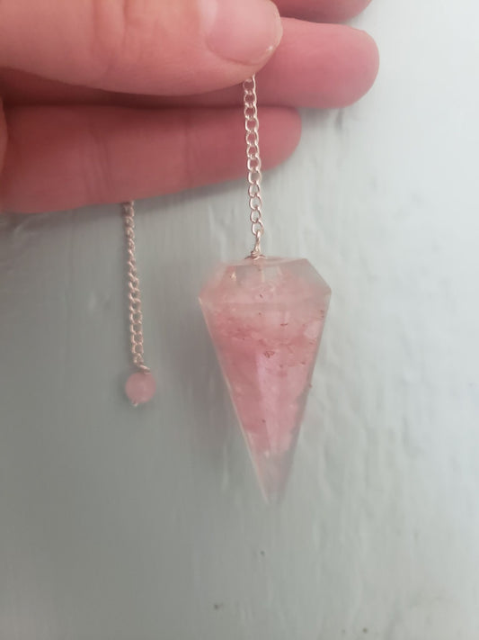 close up of 2 inch rose quartz orgonite pendulum including an 8 inch silver chain.