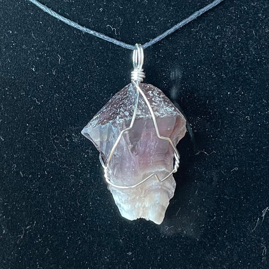 silver wire wrapped raw amethyst crystal pendant. attatched to an adjustable black cord.  It's transluscent purple near the top and  fades into white near the bottom.  approximately 1 inch  long.  