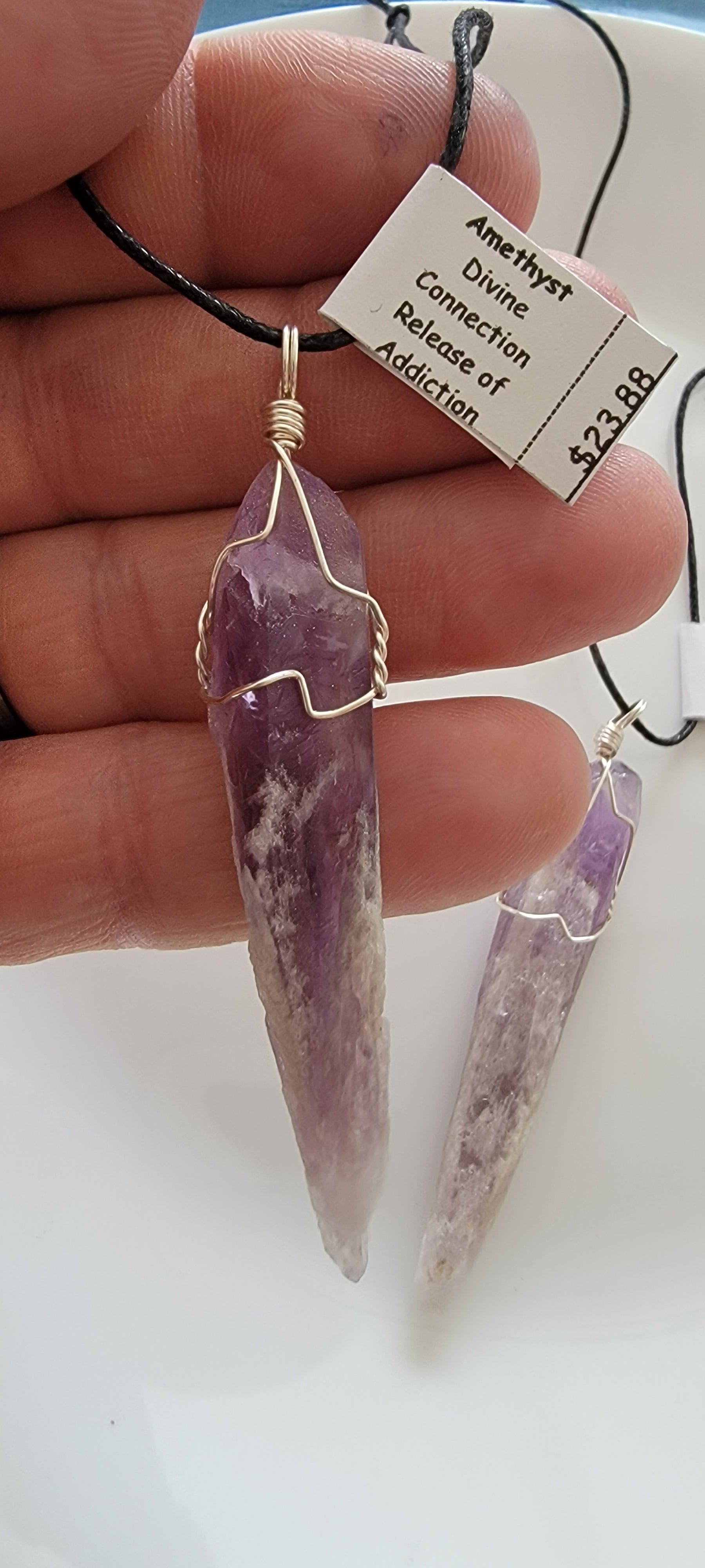 dragon tooth amethyst crystal silver wire wrapped pendant, approximately 2 inches long, attarched to an adjustable black cord.  