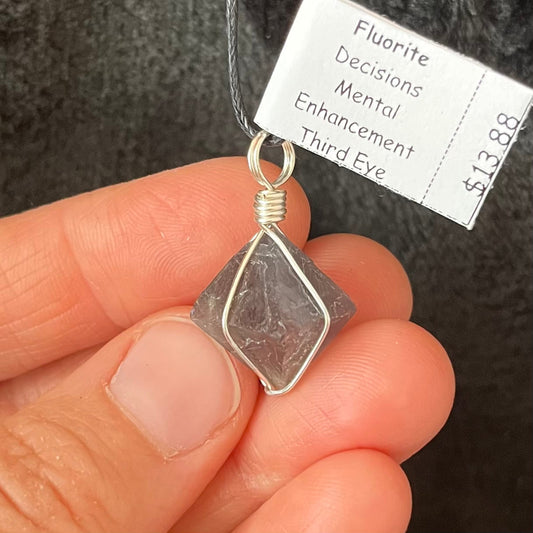 silver wire wrapped fluorite octagon crystal pendant, attatched to a black cord, approximateley 3/4" long