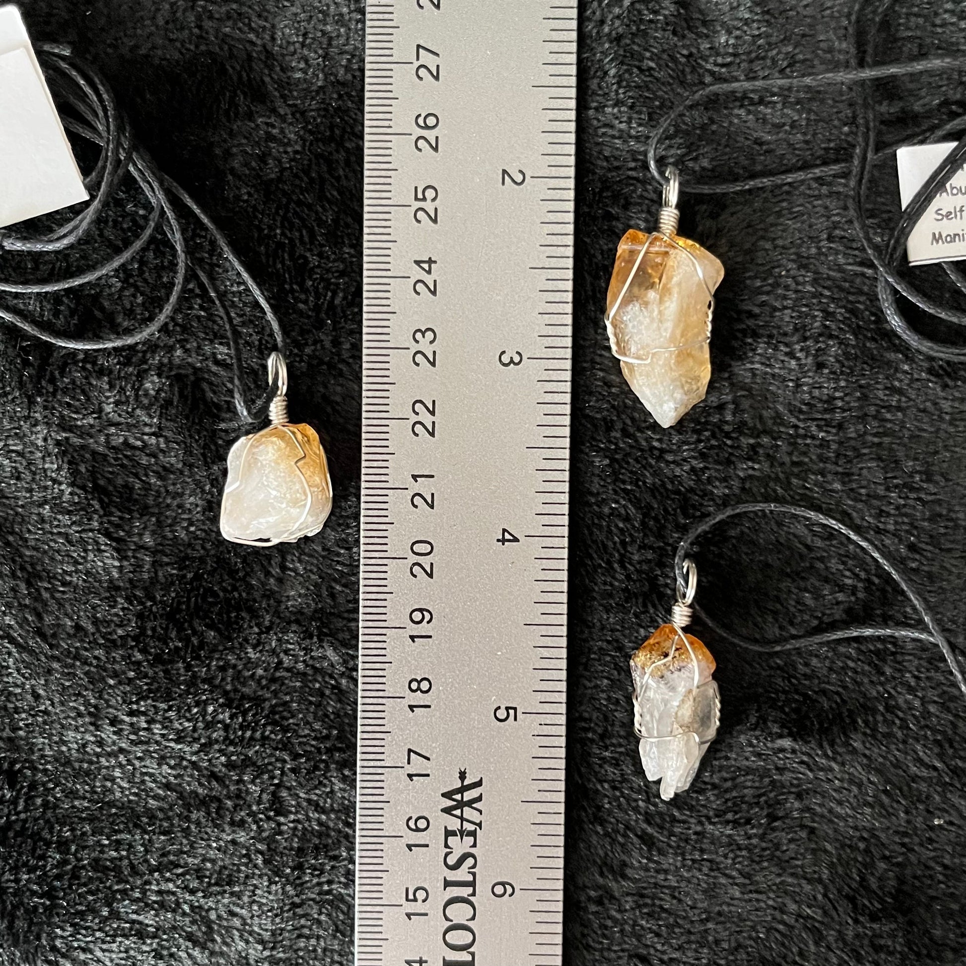 3 golden yellow translucent citrine crystals, silver wire wrapped  and attatched to ajistable black cords. displayed next to a ruler. Pendants are approximately 3/4-1" long 