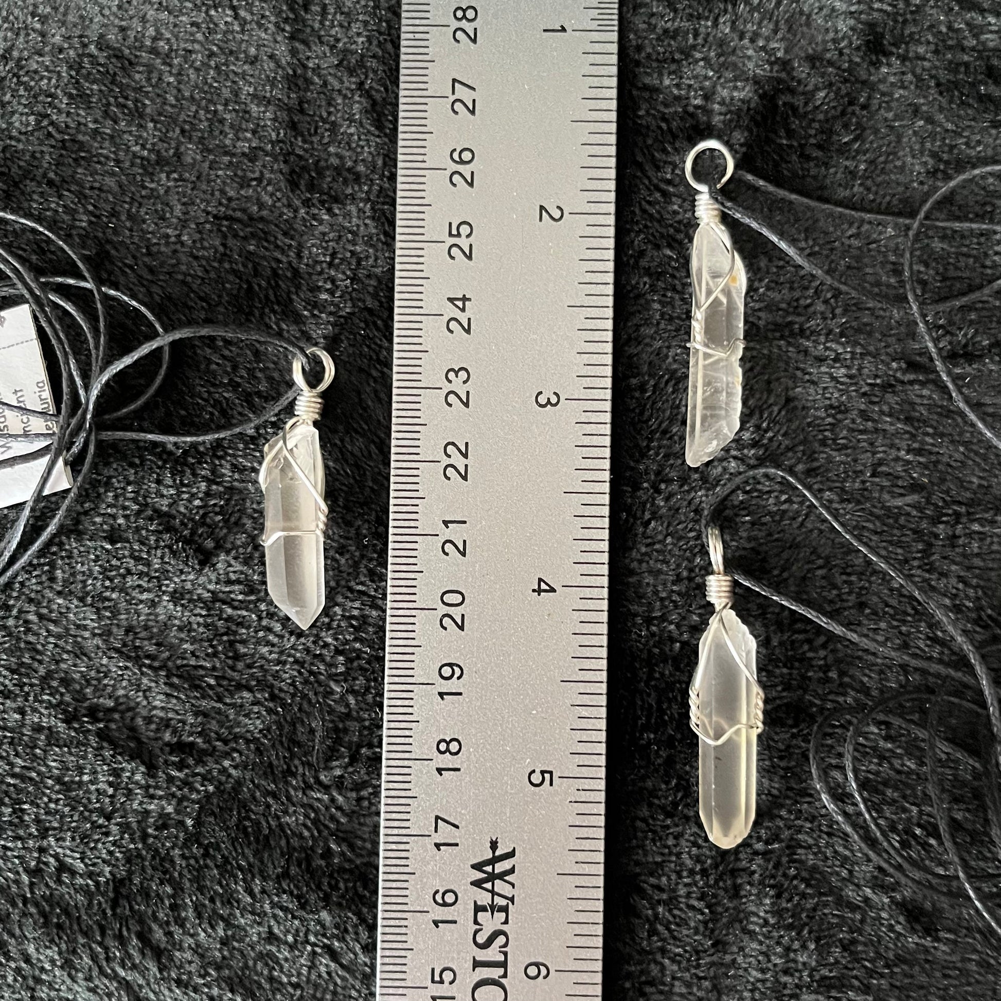 3 Silver wire wrapped dazzling lemunian quartz point pendants attarched to adjustable black cords, displayed next to a ruler.  Stone is approximately 1" - 1 1/4" long.