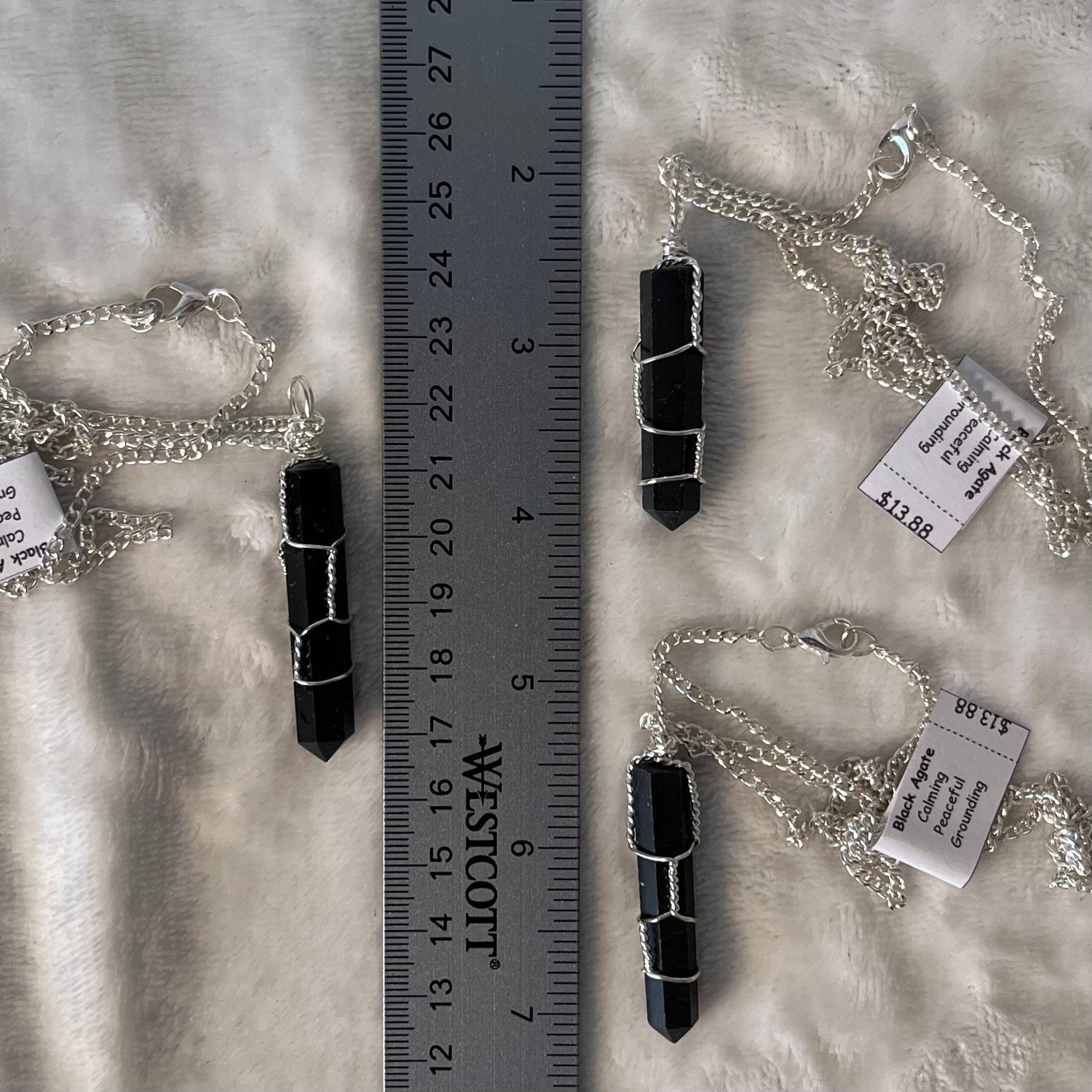 3, 1 1/2" black agate crystal point, handmade, silver wire-wrapped pendants attached to 20 inch silver chains, displayed next to a ruler.