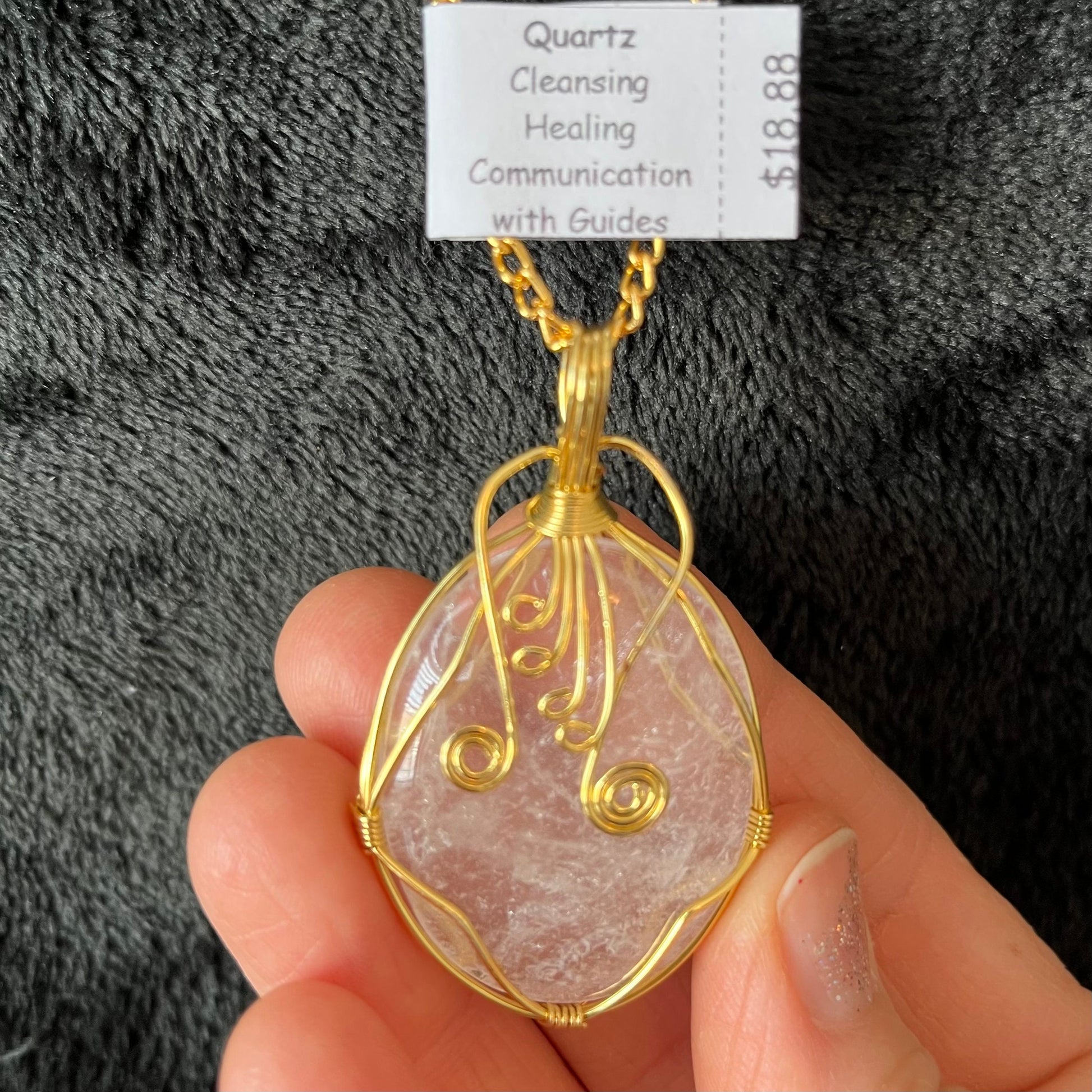 gold fancy wire wrapped oval clear quartz stone pendant attatched to a gold tone chain.