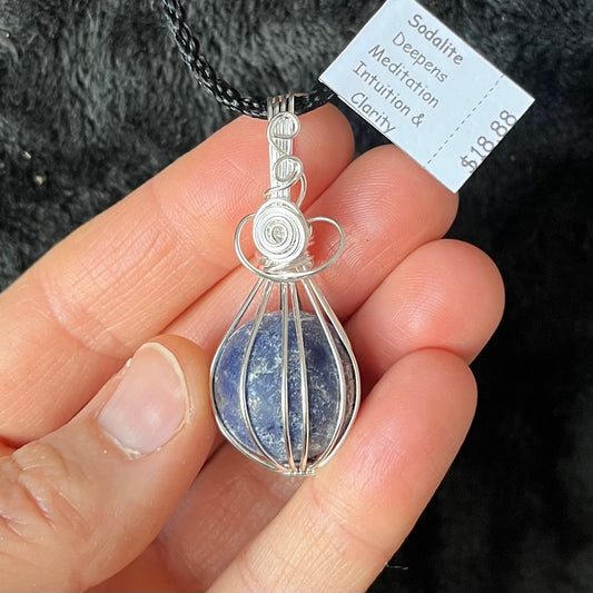 Ornately silver wire wrapped basket containing a blue amd grey sodalite sphere approximately 1/2" in diameter amd attatched to a black cord.