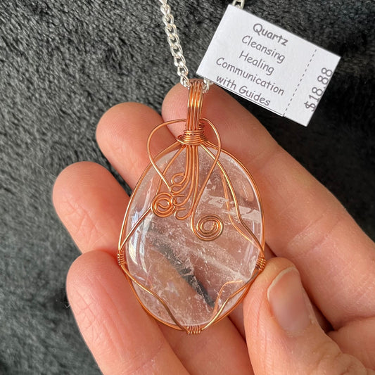 Fancy copper wire wrapped clear quartz oval stone pendant attatched to a silver chain