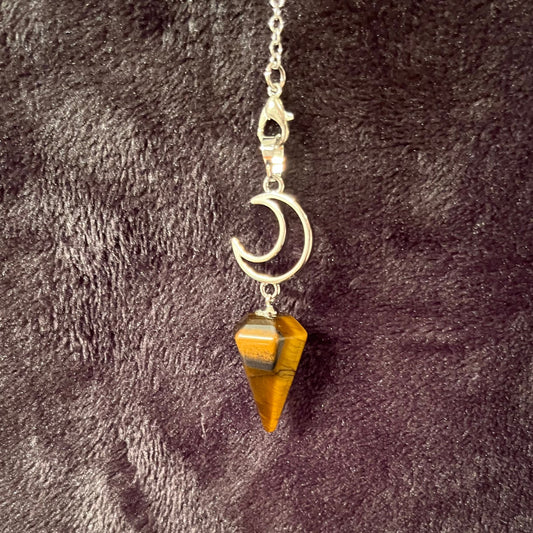 close up of a 1 inch bronze and brown marbled tiger eye  pendulum suspended from a silver creacent moon charm attatched to a silver 8 inch chain.  