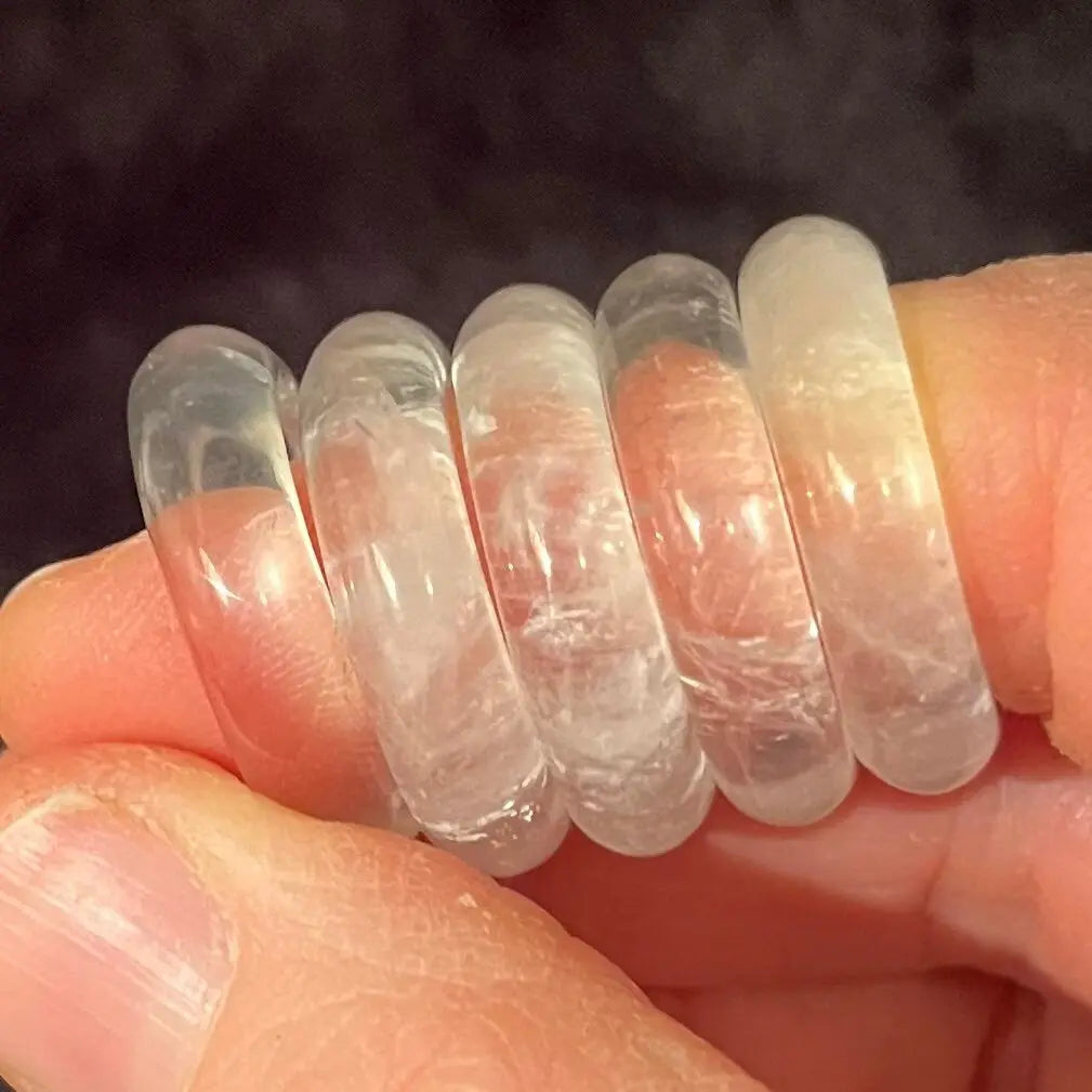 5 Size 8 bands made from beautiful marbled clear quartz crystal displayed on a forefinger.
