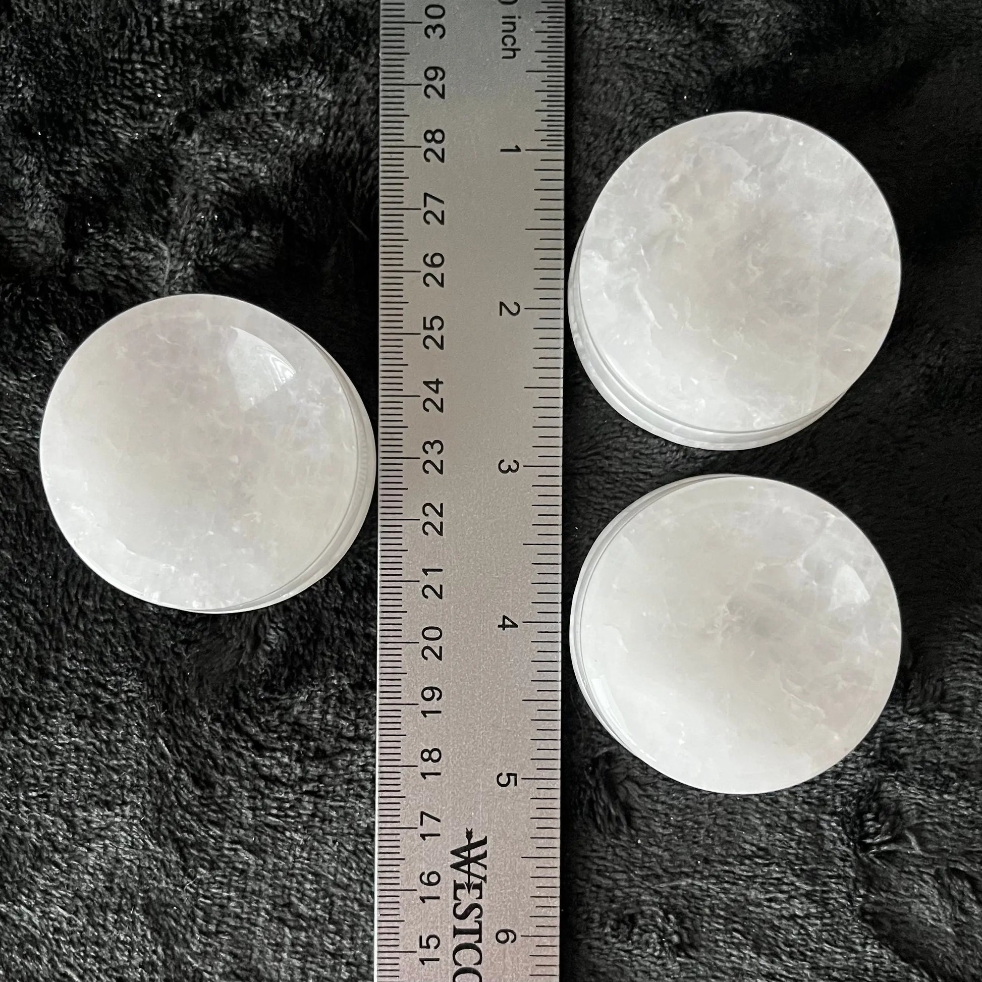 Shiny marbled quartz sphere stand approximately 1” high and 2” in diameter, displayed next to a ruler to show size.
